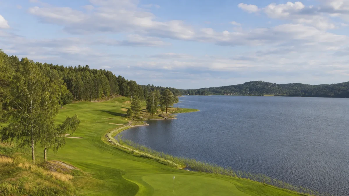 Fairway och mjukt formade kullar intill Ullnasjön på golfbanan i Ullna