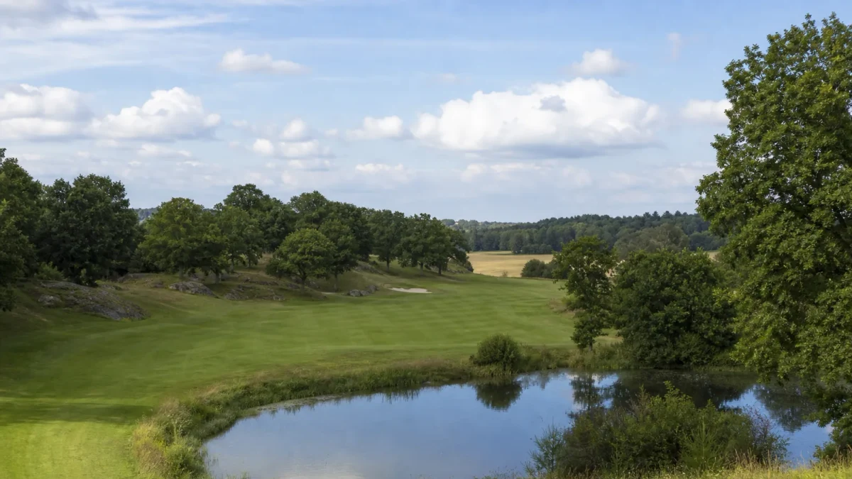Fairway och green bland ekkullar och vattenhinder på Viksjö Golfklubb
