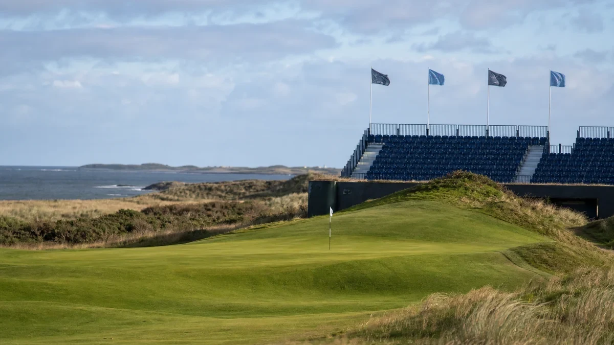 Green på linksbana vid havet med tävlingsläktare och flaggor för guiden om Scottish Open